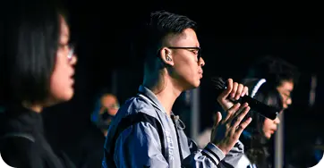 Worship leader singing into a microphone during a church service
